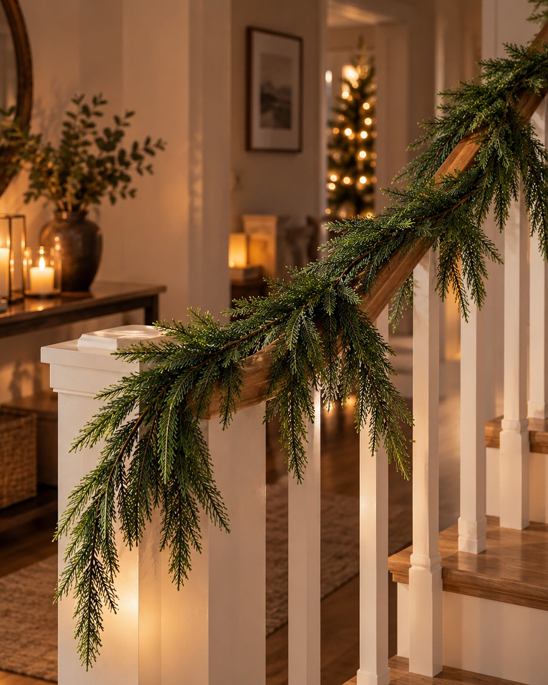 Norfolk pine garland wrapped along a white staircase banister