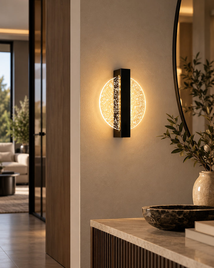 Luminous Halo round LED wall light glowing beside a round mirror in a warm living room