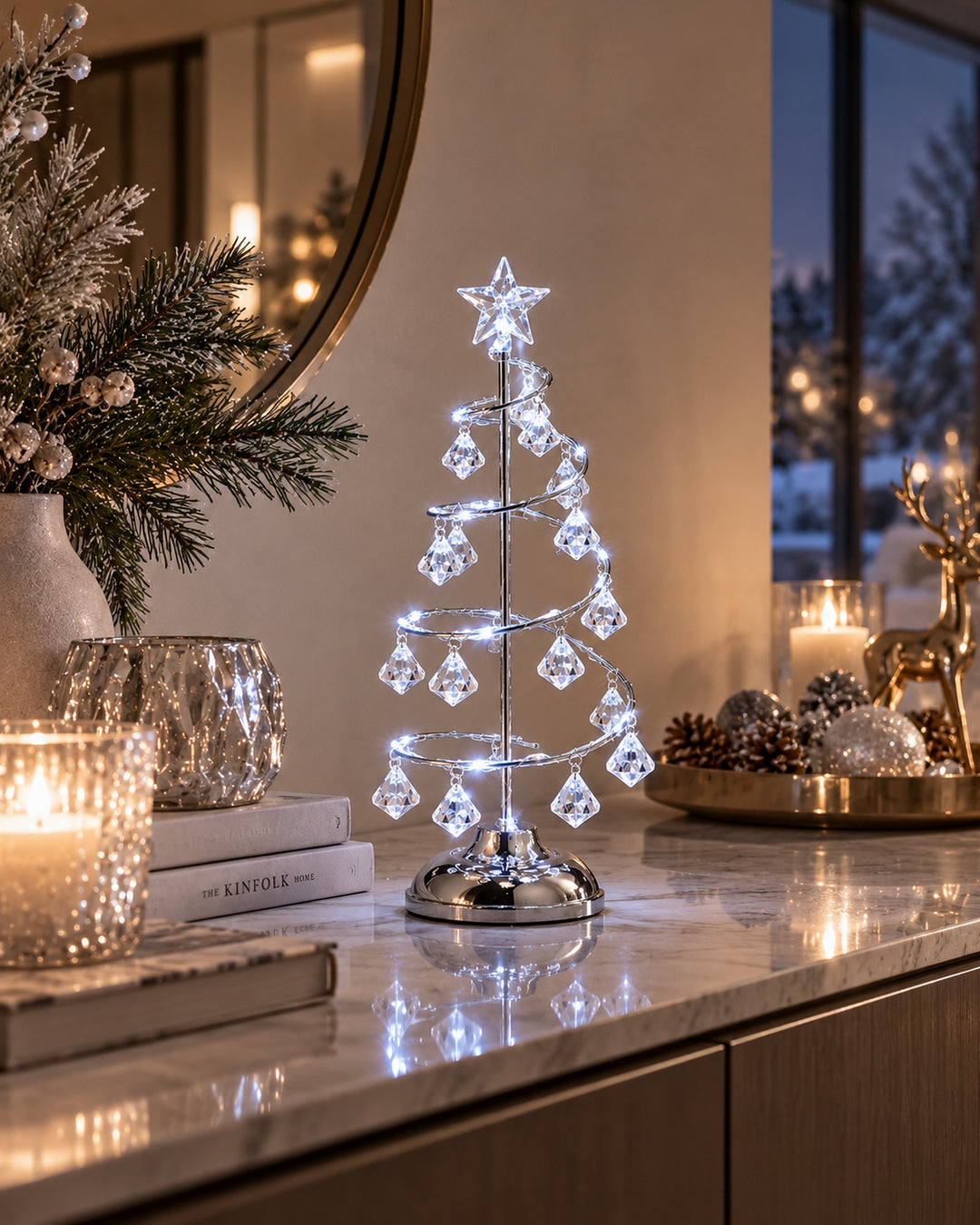 Silver-tone spiral Christmas tree light with crystal drops on a marble console