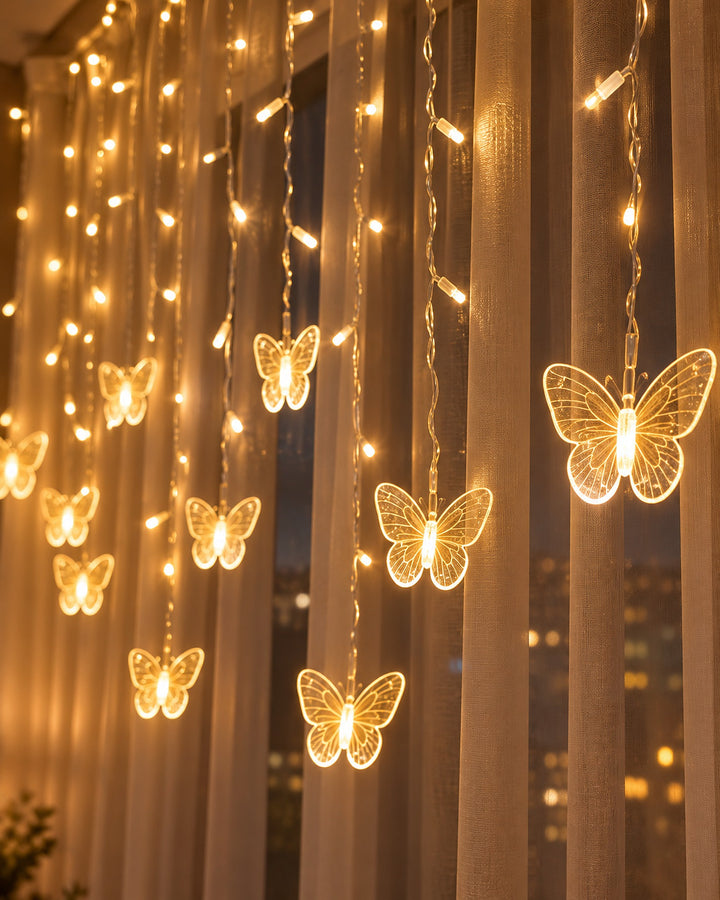 Butterfly curtain lights glowing in front of a window at night, close-up