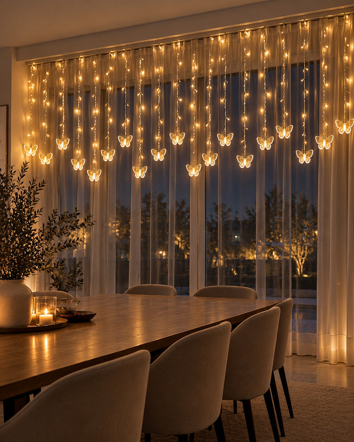 Butterfly curtain lights across a dining room window at night