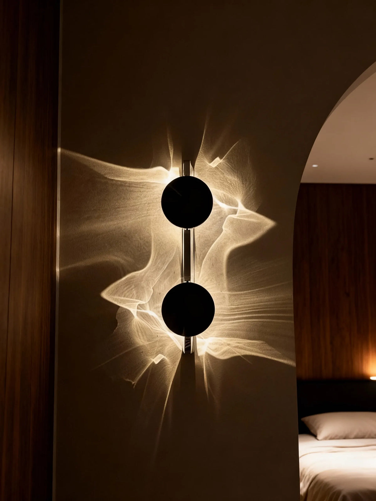 Double head halo wall lamp casting a glowing halo pattern on a bedroom wall beside an arched doorway