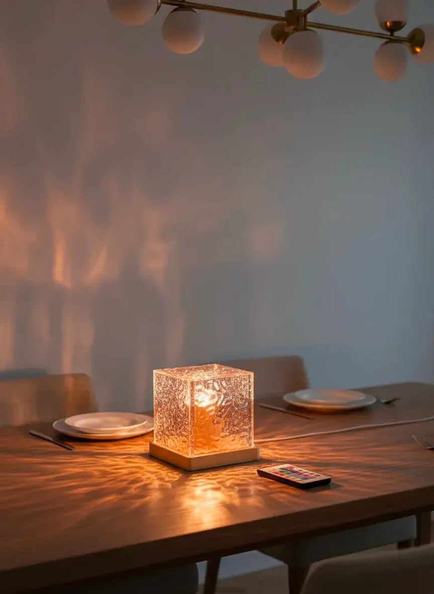 Crystal cube lamp as a table centerpiece on a dining table, casting warm patterns on the wall