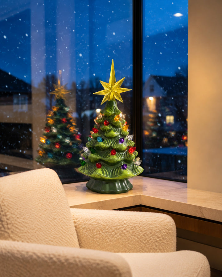 Ceramic Christmas tree by a snowy window at night