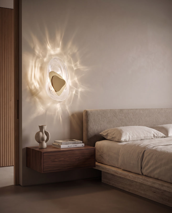 Gold Ripple glass wall light casting water-like reflections above a floating walnut bedside table