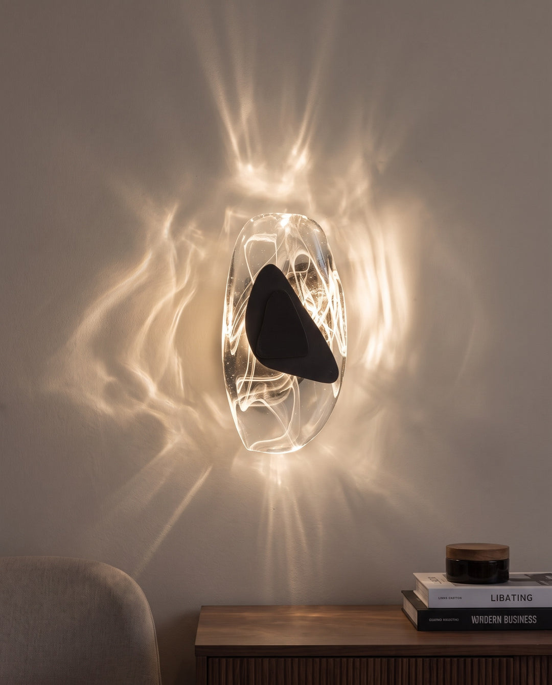 Black Ripple wall light in warm white light, projecting water-like ripples on the wall