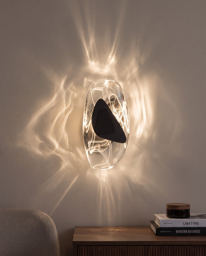 Black Ripple wall light in warm white light, projecting water-like ripples on the wall