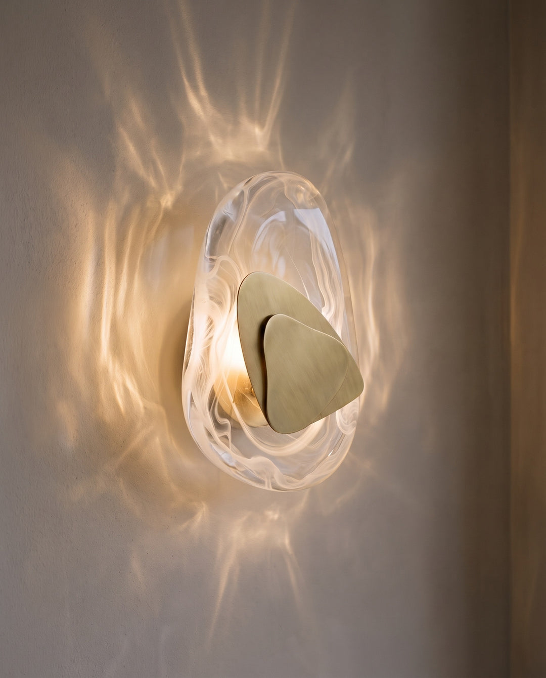 Gold Ripple wall light in warm white light, projecting water-like ripples on the wall
