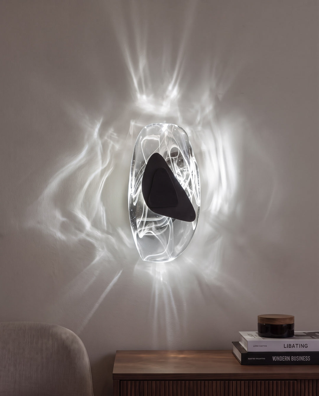 Black Ripple wall light in cool white light, projecting water-like ripples on the wall