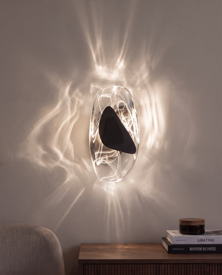 Black Ripple wall light in natural white light, projecting water-like ripples on the wall