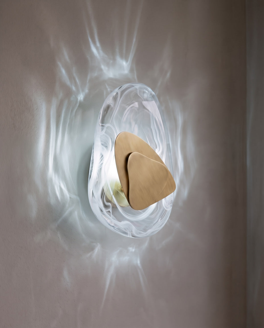 Gold Ripple wall light in cool white light, projecting water-like ripples on the wall