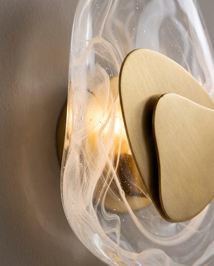 Close-up of the swirled glass and brushed gold plate of the Ripple wall light