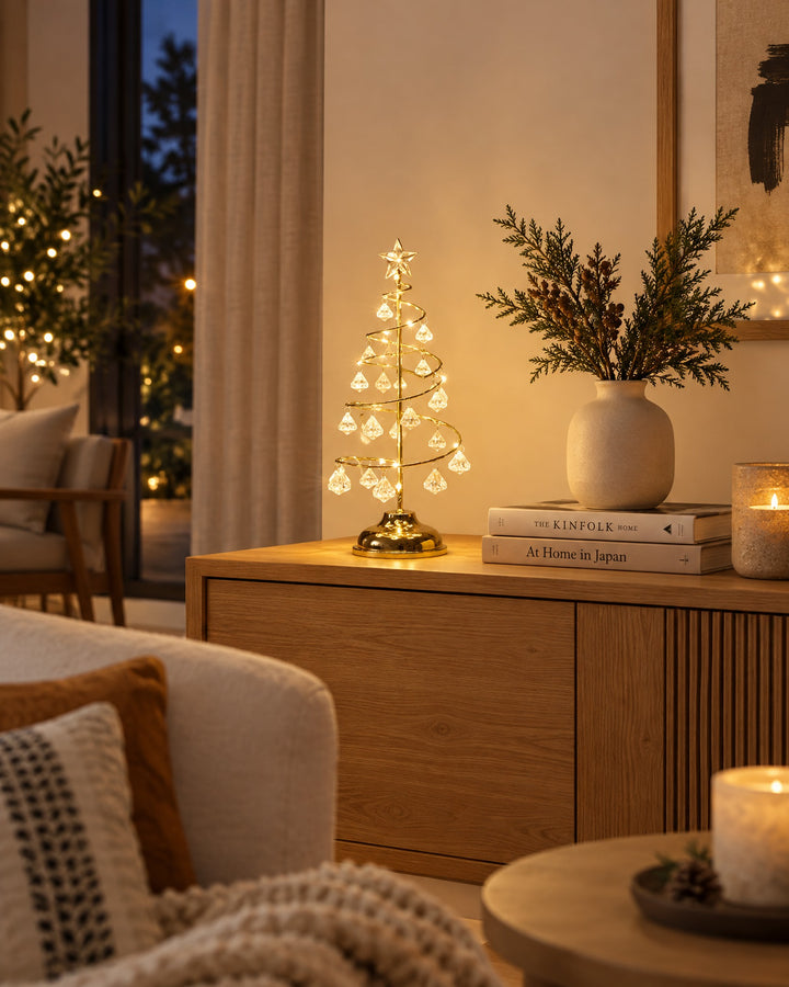 Gold-tone spiral tree light glowing on a wooden sideboard in a living room