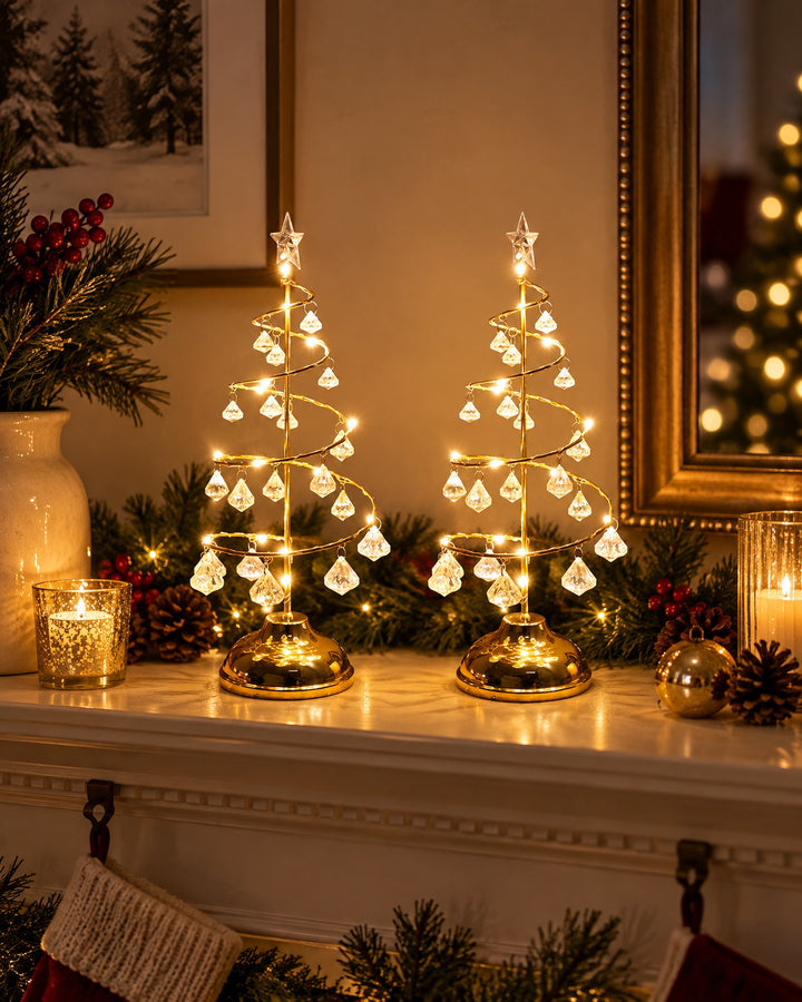 Two gold-tone spiral Christmas tree lights glowing side by side on a mantel
