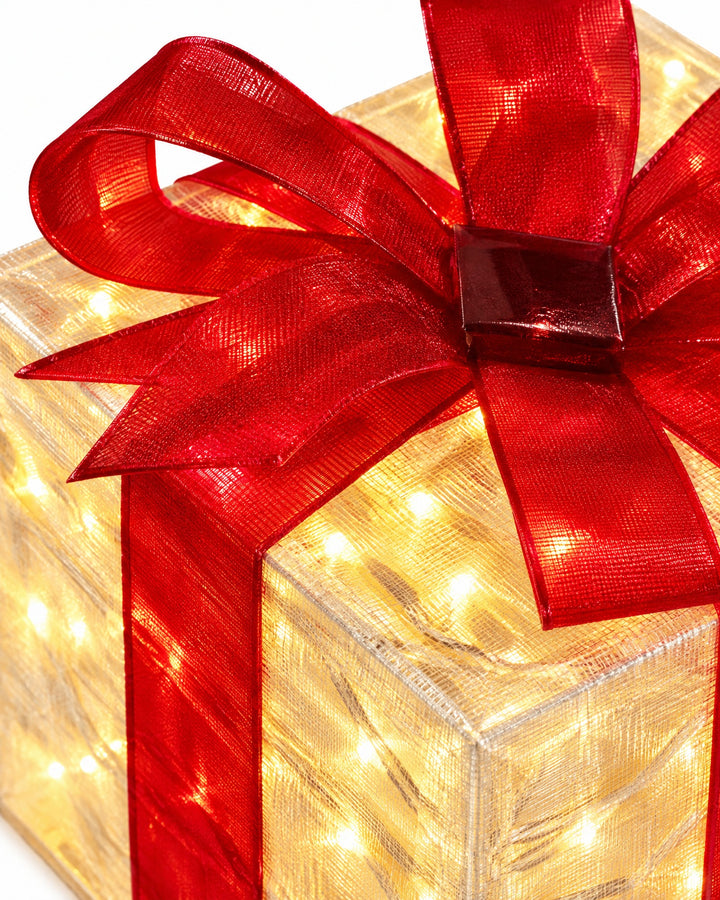 Close-up of a red bow and the glowing cover of a gift box