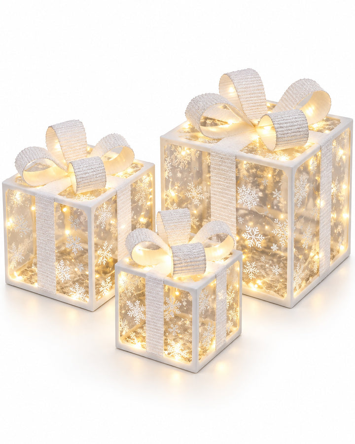 Set of 3 illuminated white gift boxes with snowflakes and white bows on a white background
