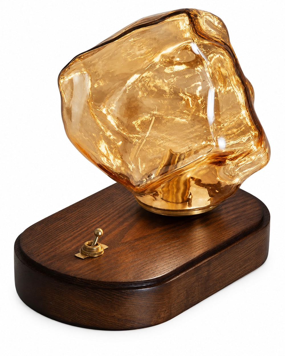 Ice rock glass table lamp with an amber shade and a dark oval base, three-quarter view on a white background