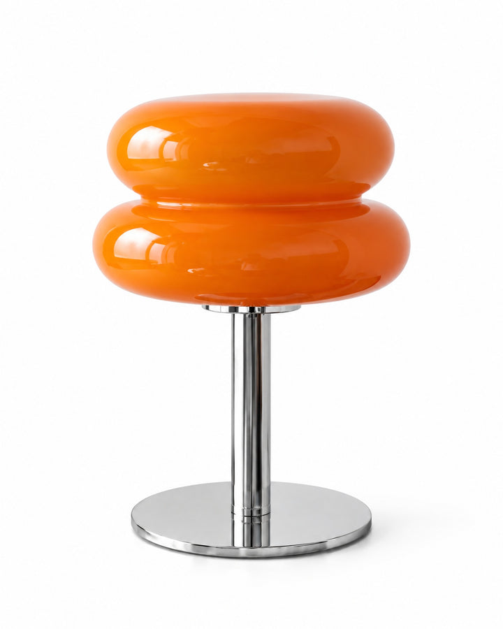 Orange macaron glass table lamp with a silver-tone stem and round base on a white background