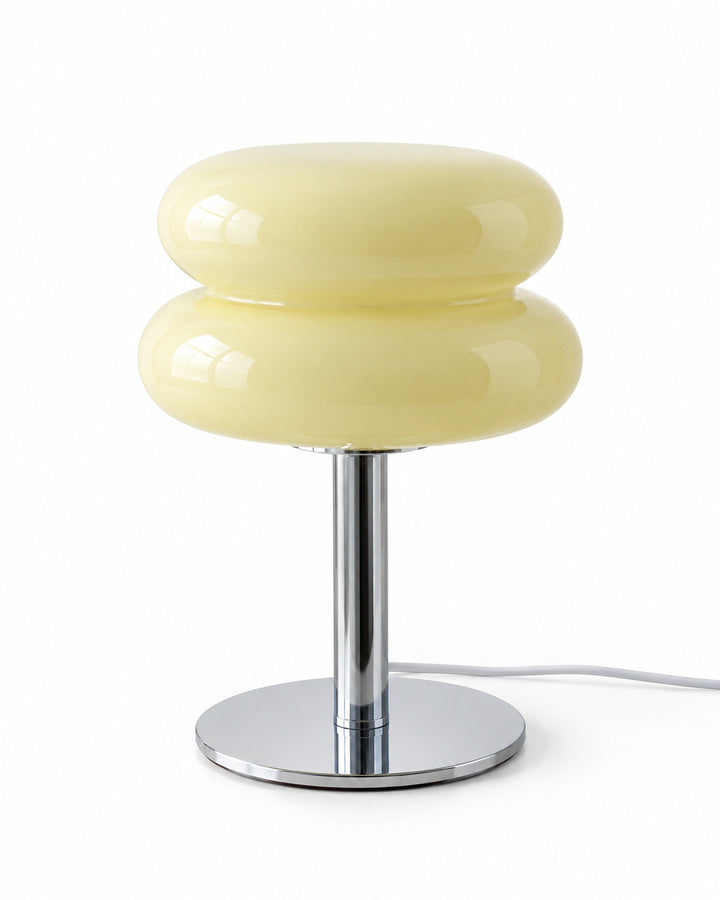 Cream macaron glass table lamp with a silver-tone stem and round base on a white background