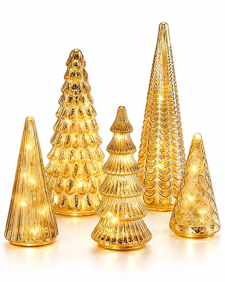 Set of five lit gold mercury glass Christmas trees of different heights on a white background