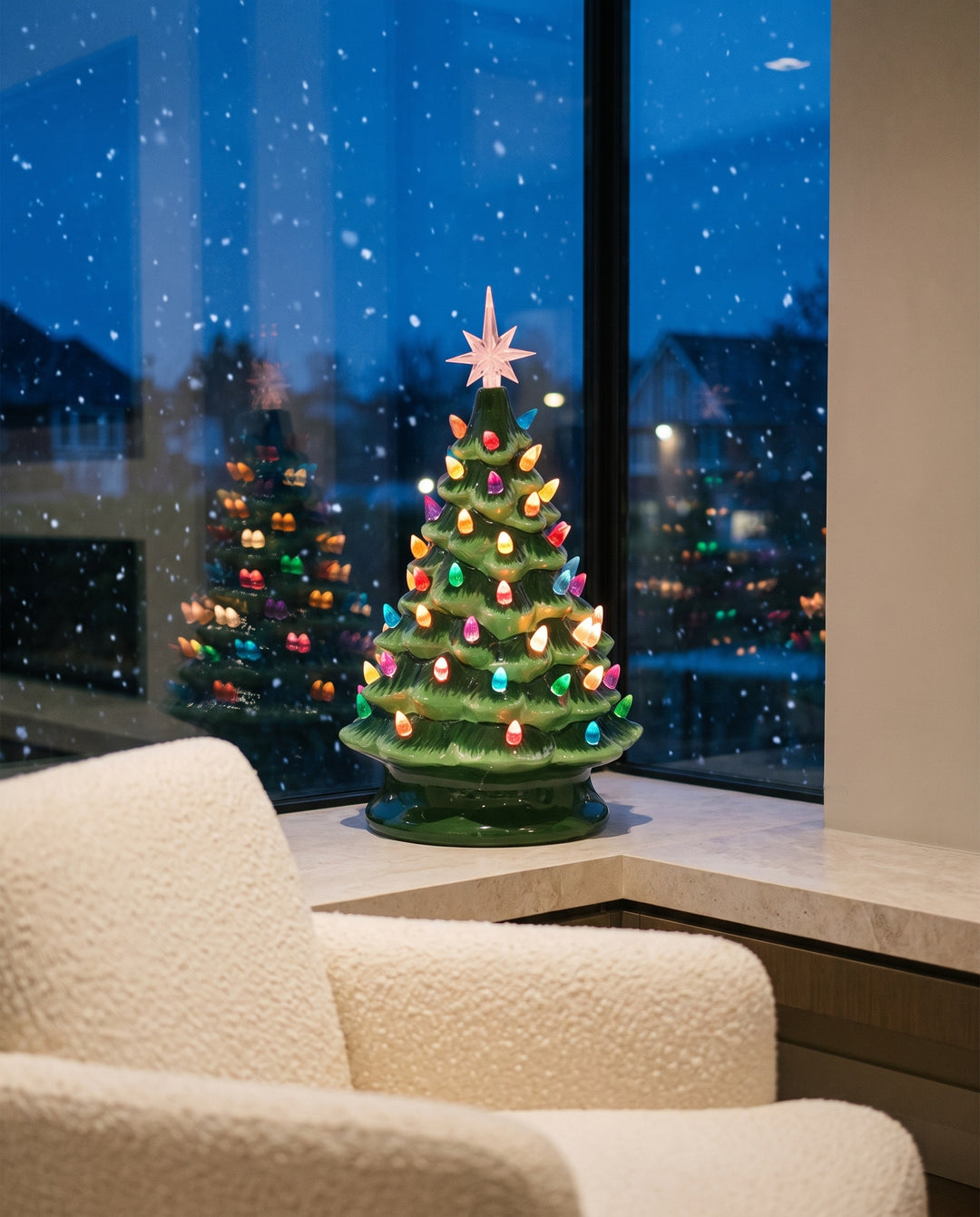 Ceramic Christmas tree lit on a stone window sill while snow falls outside