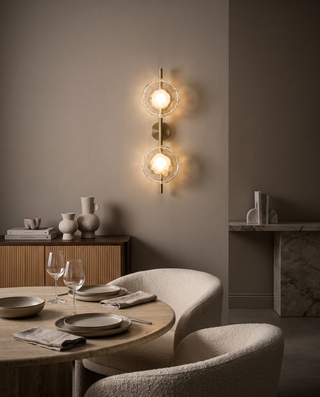 Orbe double head wall sconce in gold with clear glass in a modern dining room