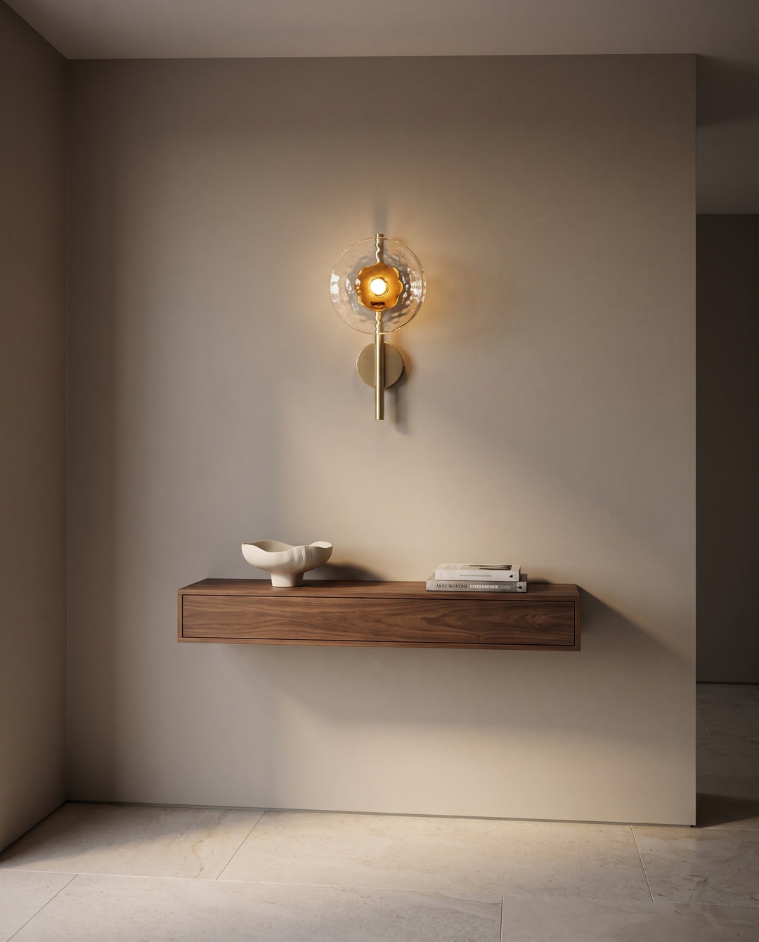 Orbe single head wall sconce in gold with amber glass above a floating walnut console