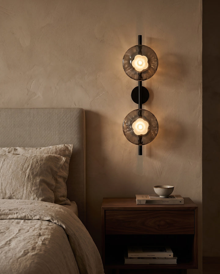 Orbe double head wall sconce in black with smoked glass beside a bed