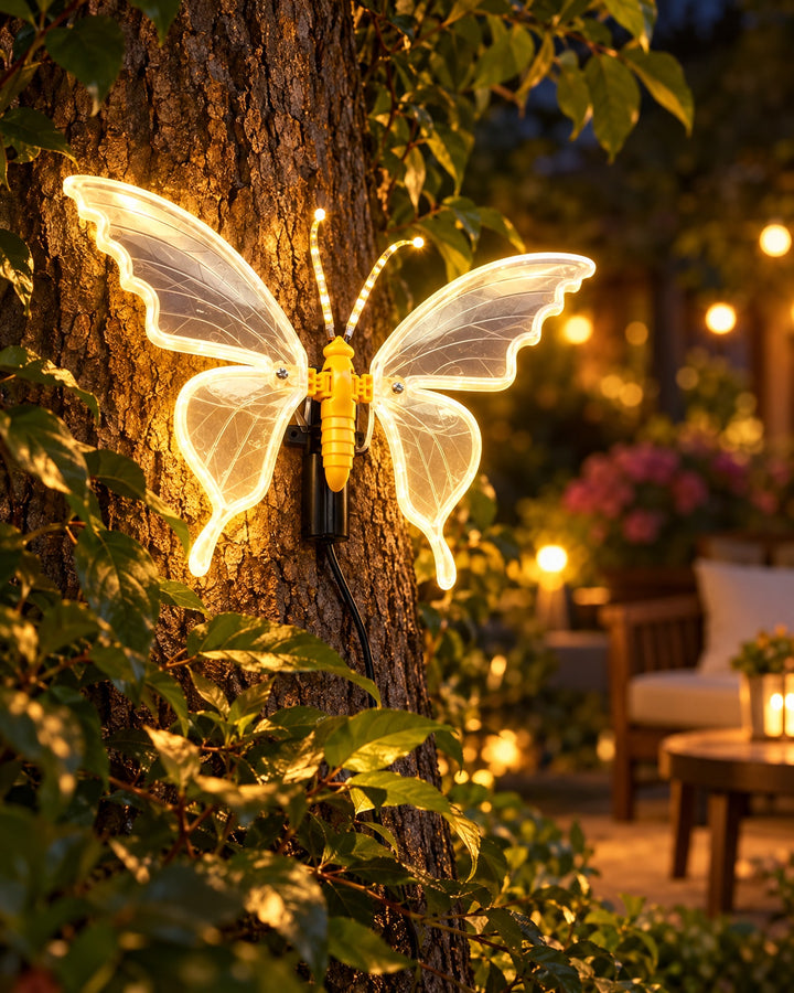 LED butterfly lamp glowing warm white on a tree trunk in a garden at night