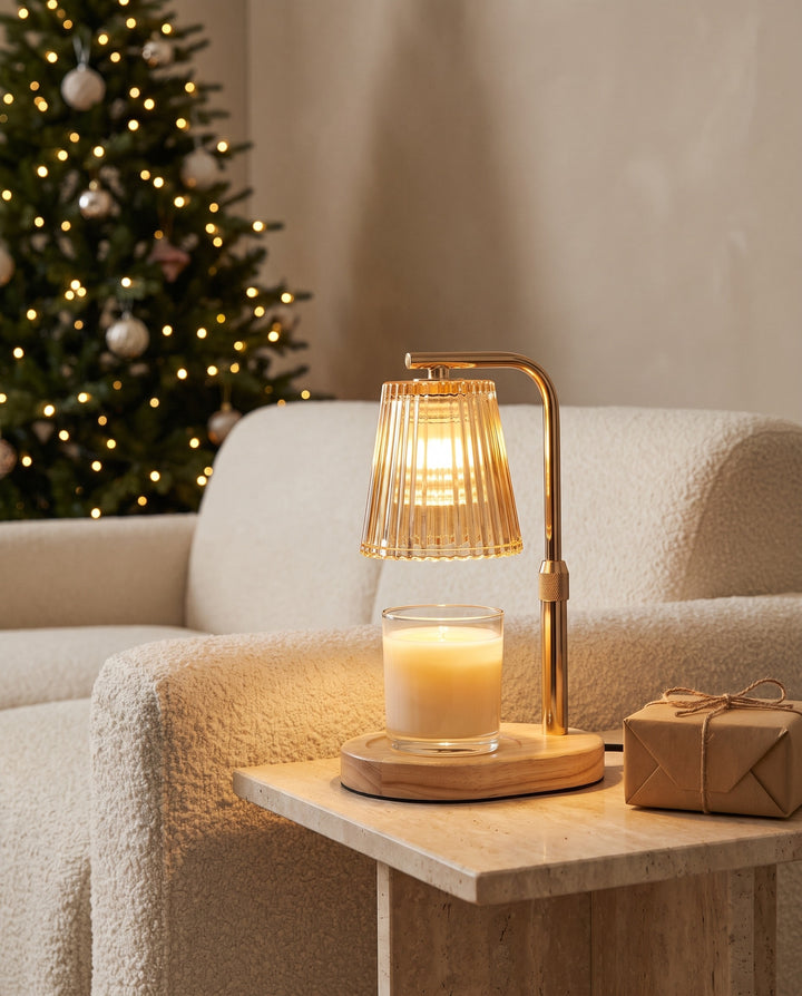 Candle warmer lamp lit on a travertine side table next to a sofa at Christmas
