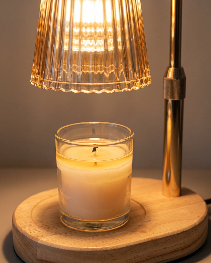 Close-up of glossy melted candle wax under the glowing amber glass shade, no flame