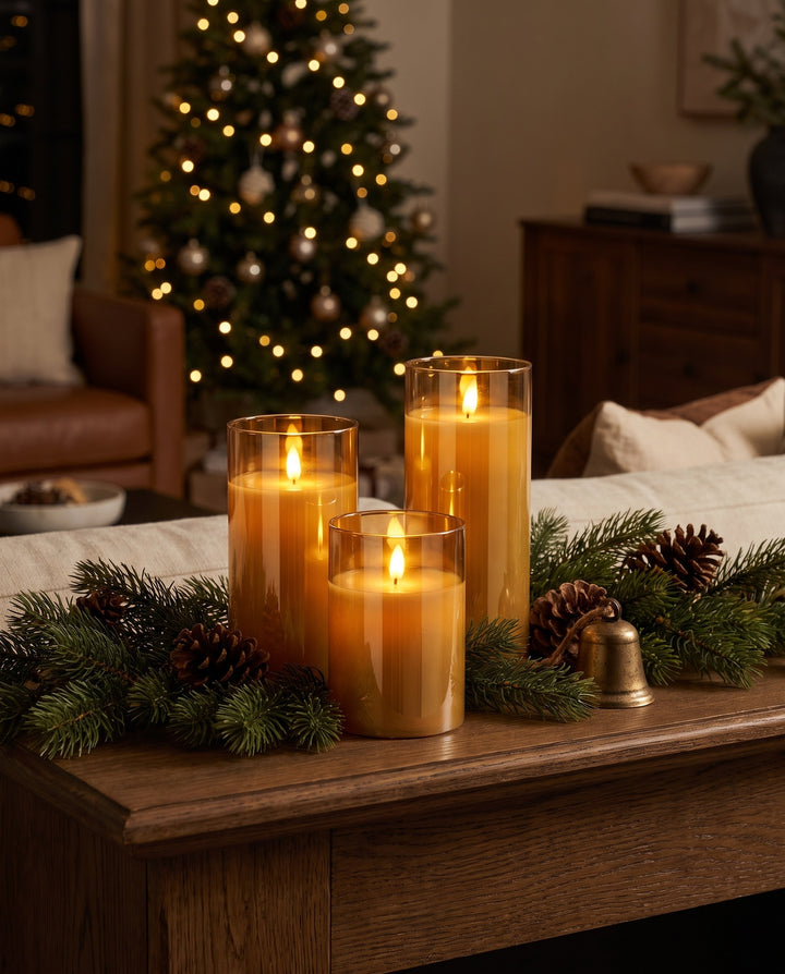 Three flameless pillar candles in amber glass on a Christmas mantel