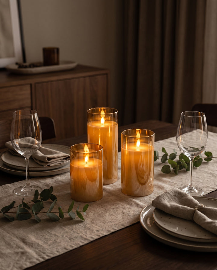Amber glass LED pillar candles on a dining table set for a winter dinner