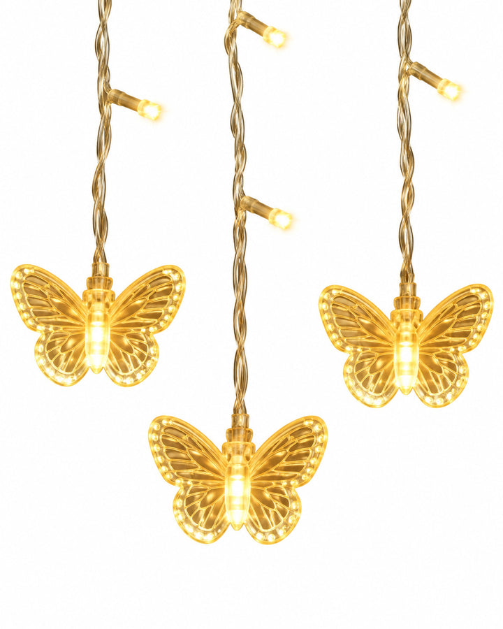 Close-up of three glowing butterflies on the curtain light strands