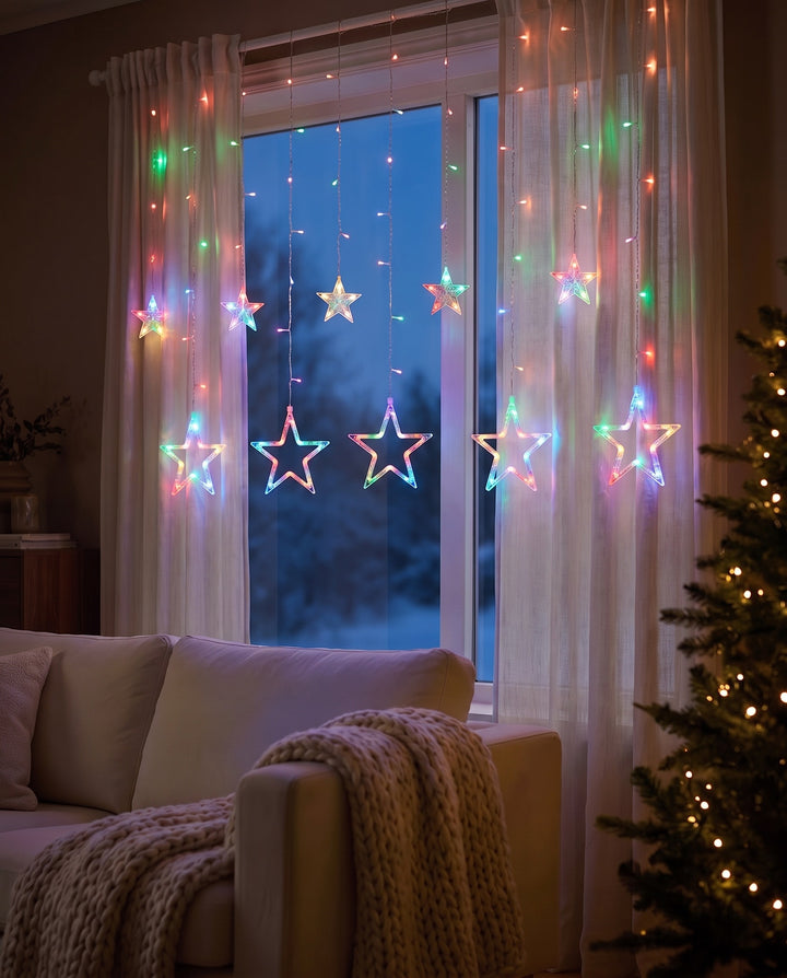 Multicolor star curtain lights in a living room window at dusk