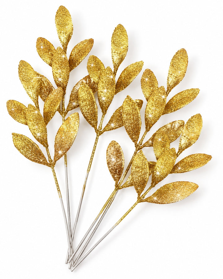 Gold glitter leaf picks seen from above on a white background