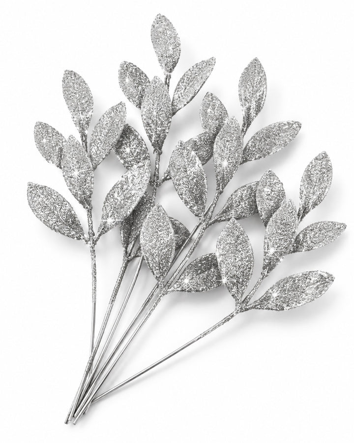 Silver glitter leaf picks seen from above on a white background