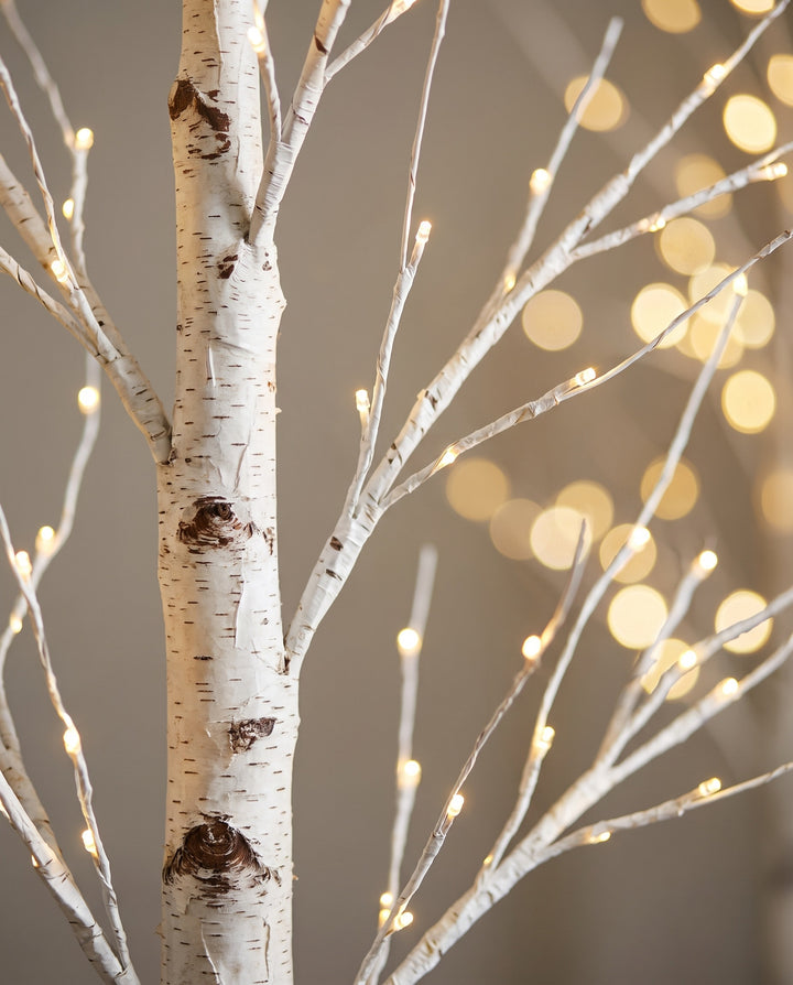 Close-up of the birch bark trunk and warm LED branches