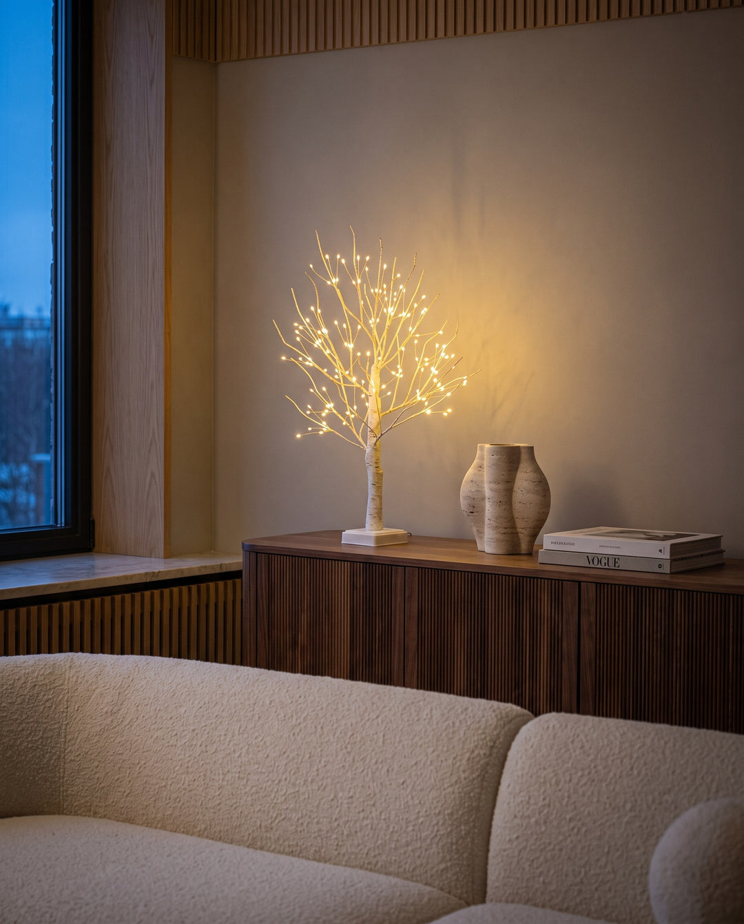144 LED birch tree lamp glowing on a fluted walnut sideboard in a modern living room