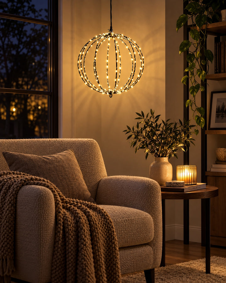 LED globe light hanging and glowing in the corner of a living room next to an armchair