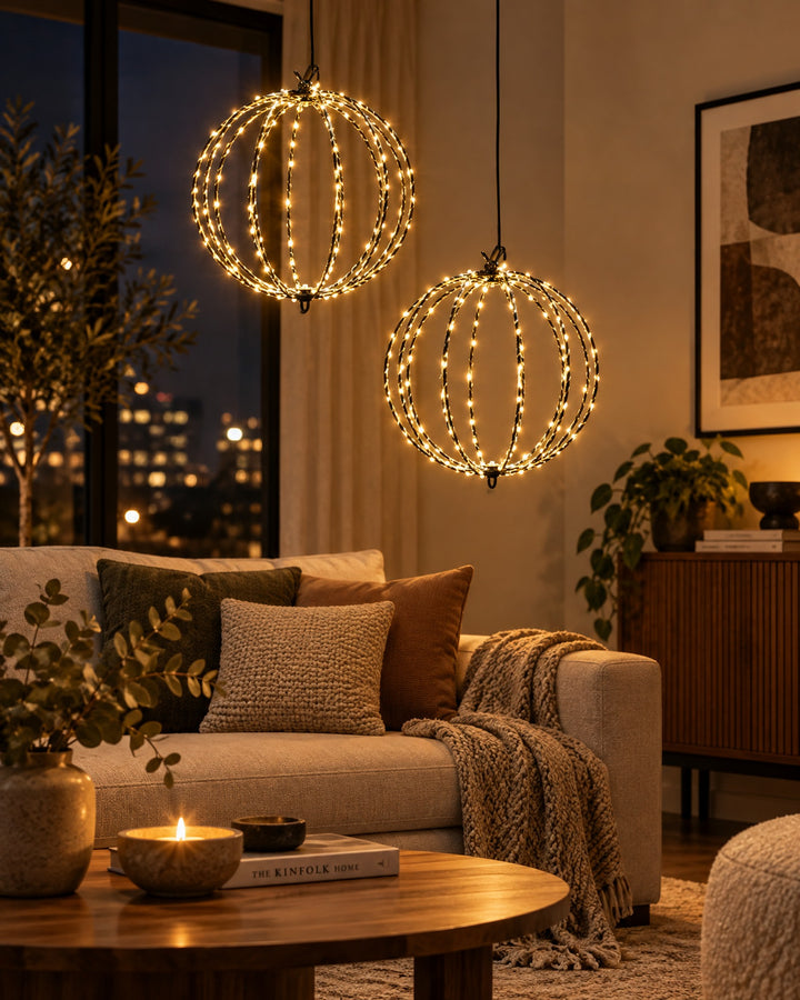Two LED globe lights hanging at different heights in a living room at night