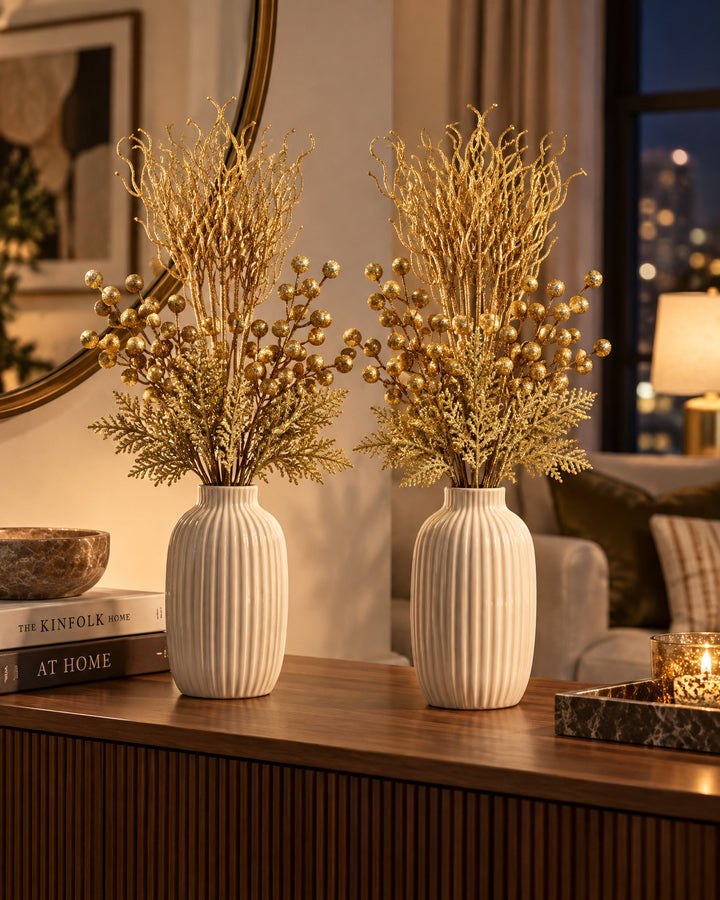 Two sets of gold glitter stems in matching vases on a console table