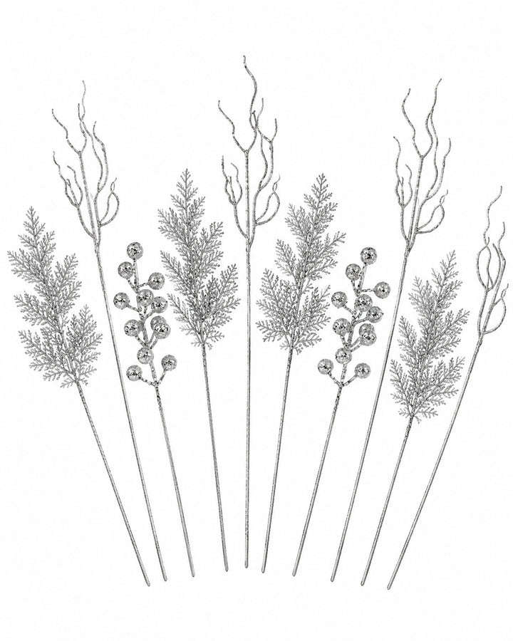 Silver glitter pine, twig and berry stems fanned out on a white background