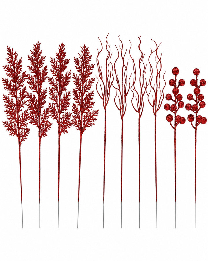 Red glitter pine, twig and berry stems standing side by side on a white background