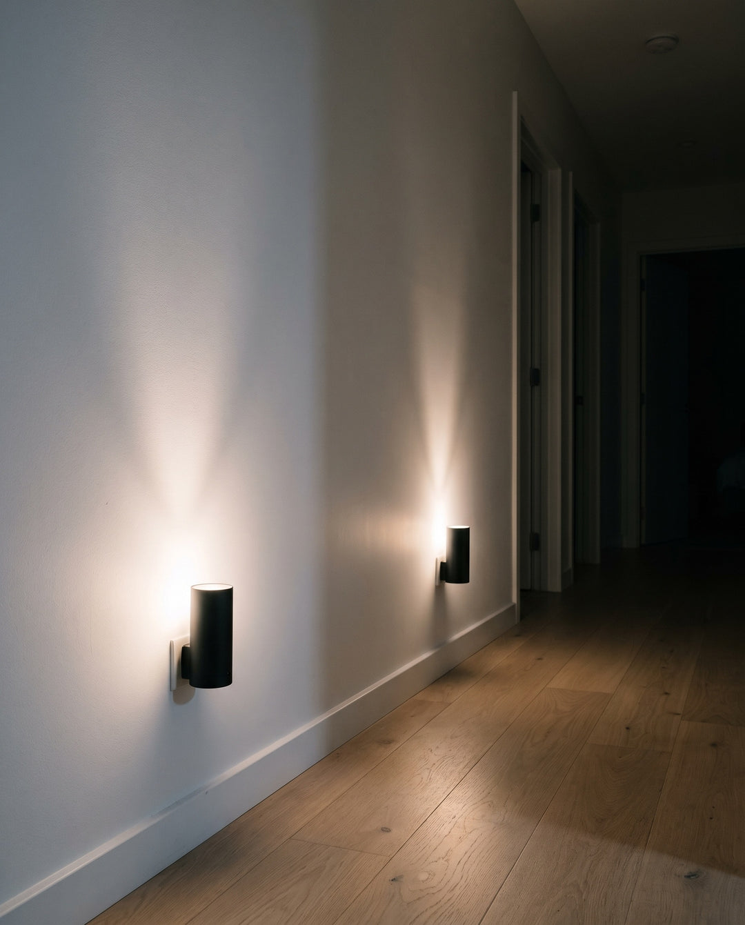 Two plug-in night lights lighting a hallway at night