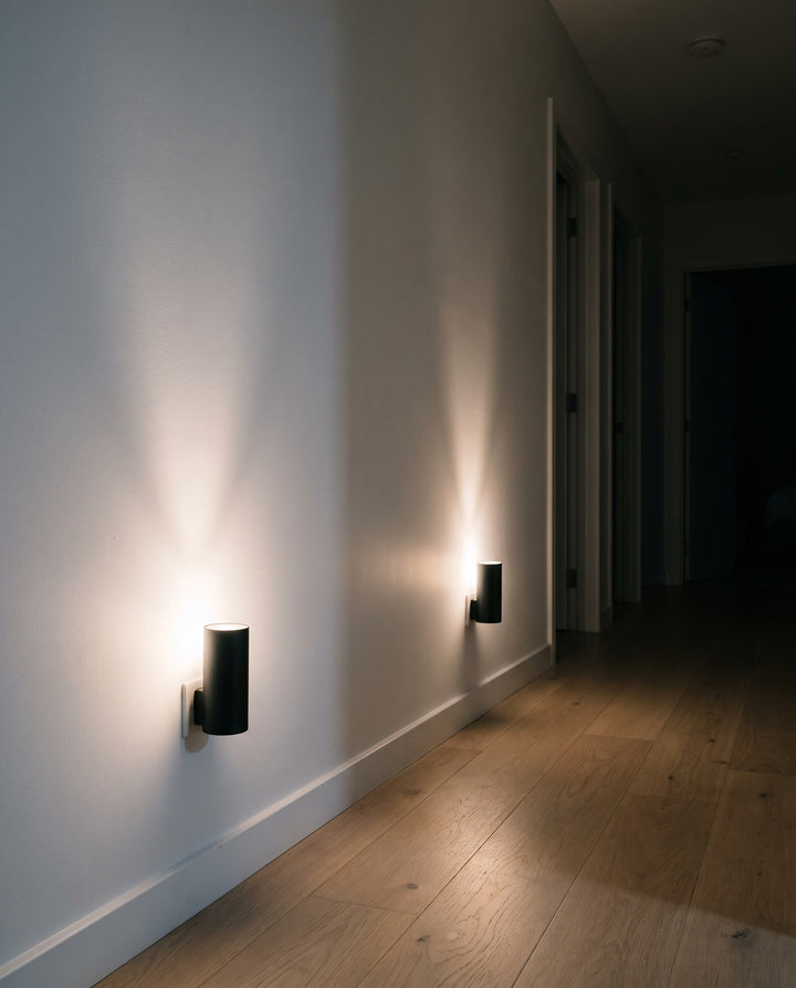 Two plug-in night lights lighting a hallway at night