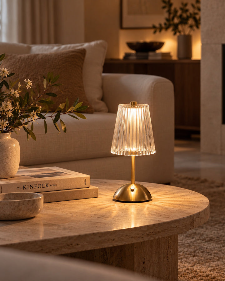 Rechargeable ribbed glass table lamp lit on a stone coffee table beside a cream sofa